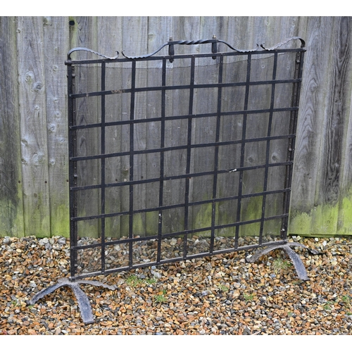 123 - #A large wrought iron and wire-mesh panelled spark guard, 140 cm w x 110 cm h o/a including base/fee... 