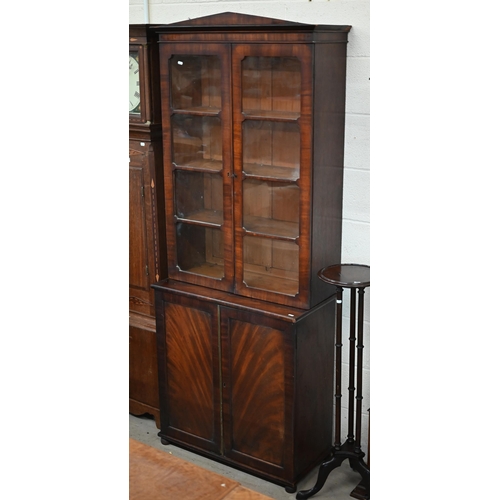 145 - A mid 19th century mahogany bookcase cabinet with two door glazed top on two door cabinet base with ... 