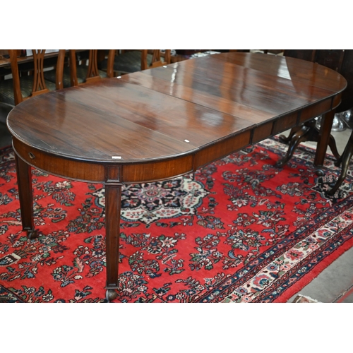 182 - An early 20th century mahogany extending wind-out action dining table, the rounded top with four lea... 