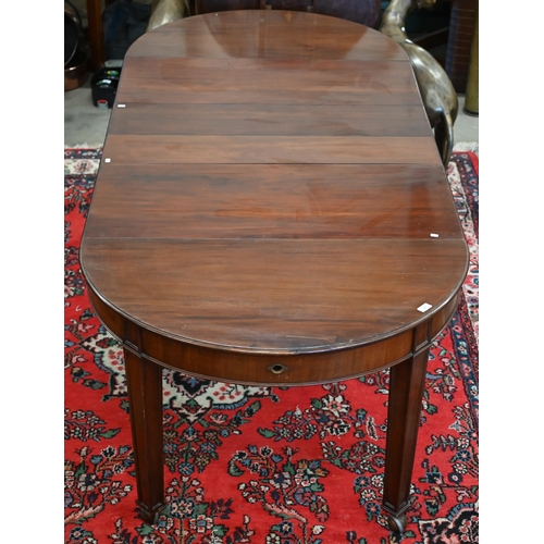 182 - An early 20th century mahogany extending wind-out action dining table, the rounded top with four lea... 