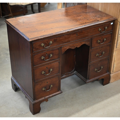 185 - A Georgian mahogany kneehole desk with recessed central cupboard and arrangement of seven drawers on... 