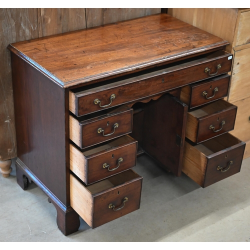 185 - A Georgian mahogany kneehole desk with recessed central cupboard and arrangement of seven drawers on... 