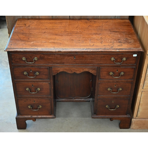 185 - A Georgian mahogany kneehole desk with recessed central cupboard and arrangement of seven drawers on... 