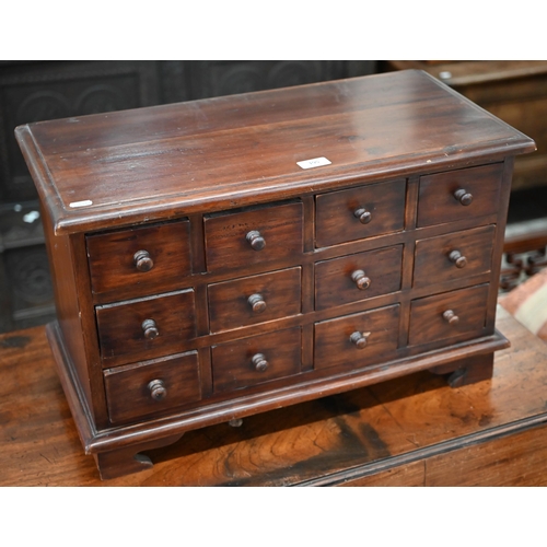 195 - A tropical hardwood table top implements chest with twelve drawers, on four bracket feet, 62 x 30 x ... 