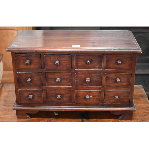 195 - A tropical hardwood table top implements chest with twelve drawers, on four bracket feet, 62 x 30 x ... 