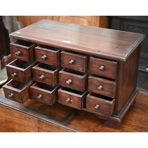 195 - A tropical hardwood table top implements chest with twelve drawers, on four bracket feet, 62 x 30 x ... 