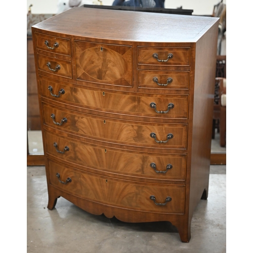 196 - A reproduction mahogany bowfront tall boy chest with an arrangement of nine drawers on splayed feet,... 