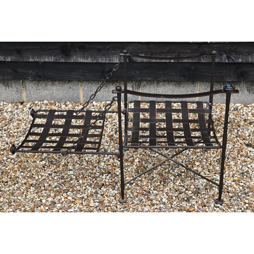 223 - A wrought iron Bugatti style indoor/outdoor reclining armchair with lattice seat and chain supported... 