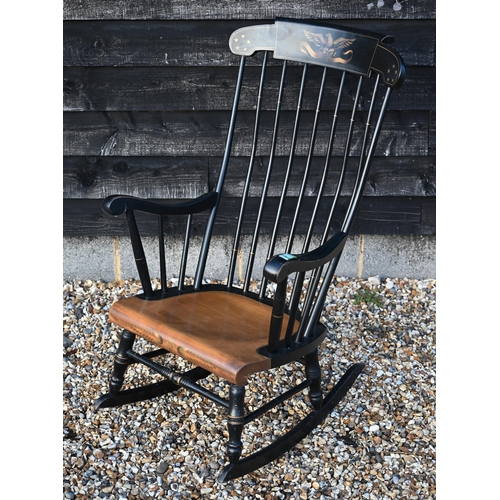 225 - An ebonised spindle back rocking chair with stencilled gilt eagle to crest rail