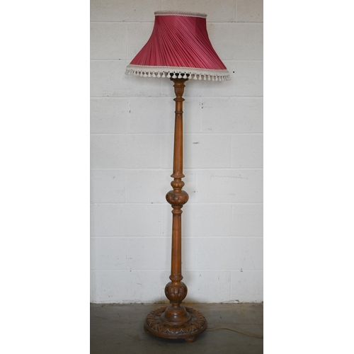 255 - A turned carved and fluted hardwood standard lamp with pleated silk shade