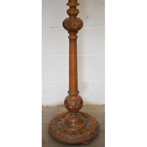 255 - A turned carved and fluted hardwood standard lamp with pleated silk shade