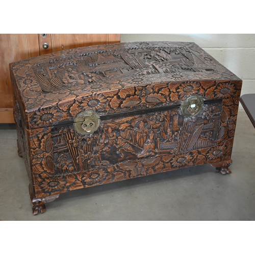 256 - A large Chinese dome-top camphorwood blanket chest extensively carved with landscapes and figures, 1... 