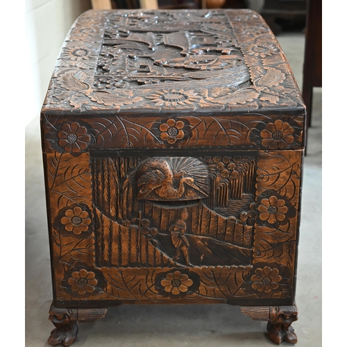 256 - A large Chinese dome-top camphorwood blanket chest extensively carved with landscapes and figures, 1... 