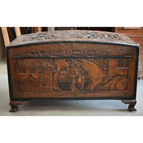 256 - A large Chinese dome-top camphorwood blanket chest extensively carved with landscapes and figures, 1... 