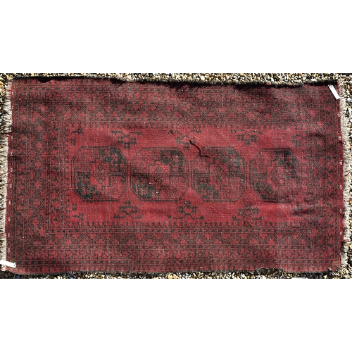 265 - A worn Afghan gul design red ground rug, 200 x 120 cm