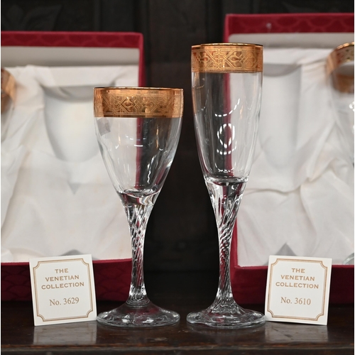 405 - A boxed set of six gilt-rimmed champagne flutes and six wine glasses to match