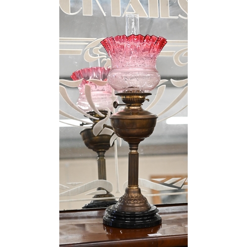 470 - A Victorian brass oil lamp on reeded column, with etched cranberry shade, 65 cm overall