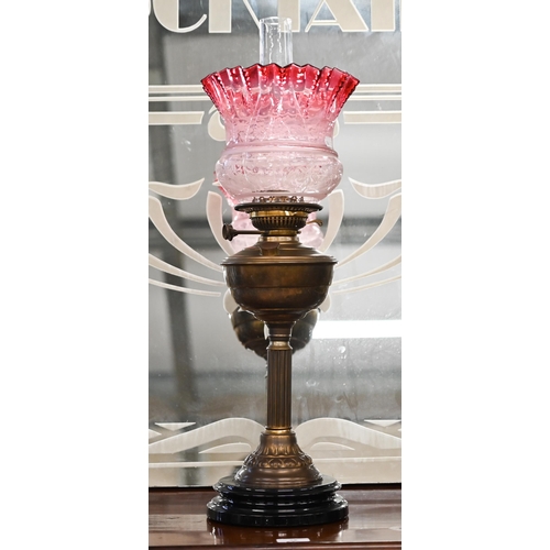 470 - A Victorian brass oil lamp on reeded column, with etched cranberry shade, 65 cm overall