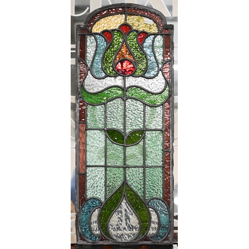 505 - An Art Nouveau leaded stained glass door-panel with stylised floral motif, 72 x 29.5 cm to/w a brass... 