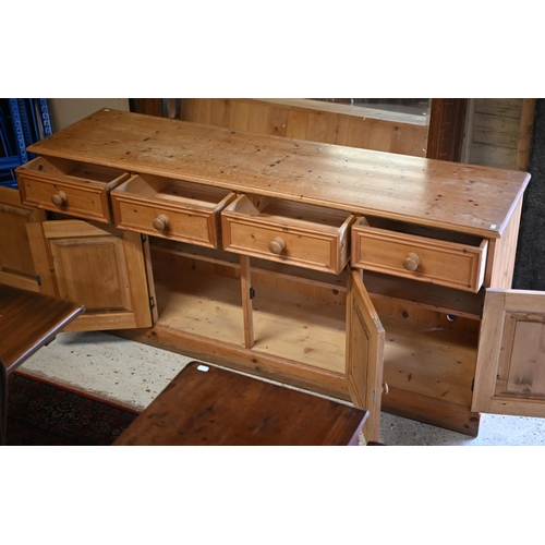 6 - A modern pine sideboard with four drawers over four cupboards, on a plinth base, 183 cm x 49 cm x 82... 