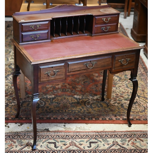 73 - An Edwardian Carlton House style writing table, with burgundy leatherette top, raised on slender cab... 