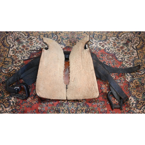 80 - WITHDRAWN A vintage tooled leather American style saddle, with straps/stirrups but a/f