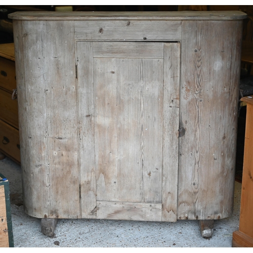 94 - An antique French stripped pine cupboard, with rounded ends centred by a single door, raised on sled... 