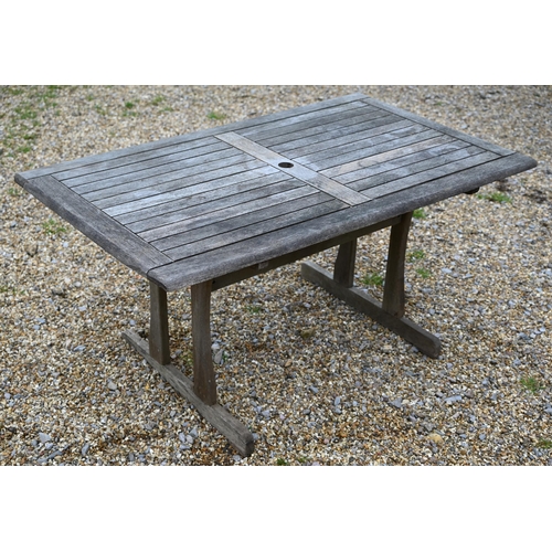 128 - A rectangular weathered teak garden/patio table 150 cm x 90 cm x 72 cm h to/w a two-seater slatted b... 