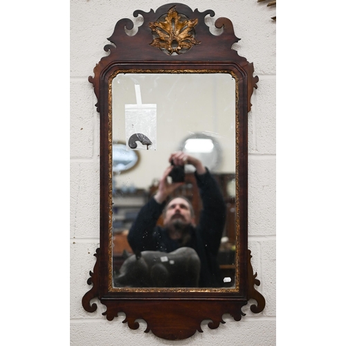 204A - A Georgian wall mirror in fret cut mahogany frame with gilt foliate crest roundel, 93 cm x 50 cm