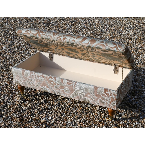 297A - A modern floral upholstered box seated footstool/ottoman on turned supports with brass casters