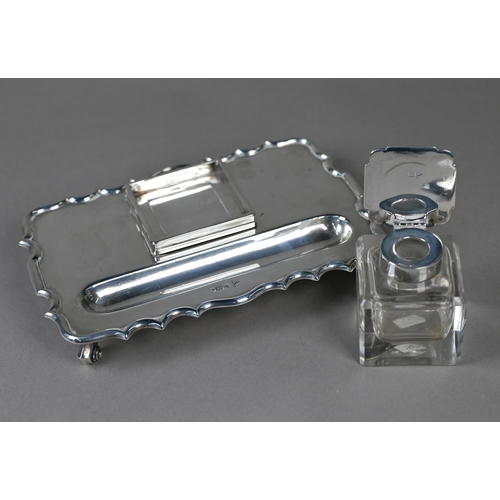 110 - A heavy quality silver inkstand with silver-topped square cut glass inkwell, shaped rim and four scr... 