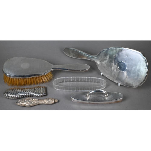 115 - An engine-turned silver hairbrush and mirror set, to/w a similar nail-buffer in glass pot (lacks pad... 