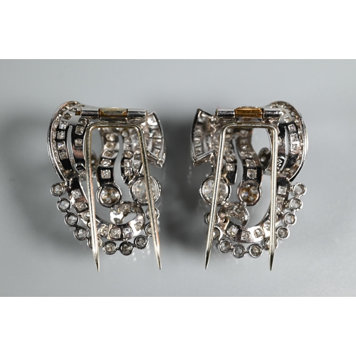 228 - A pair of Italian diamond fur clips, of opposing scroll form mounted overall with mixed cut diamonds... 