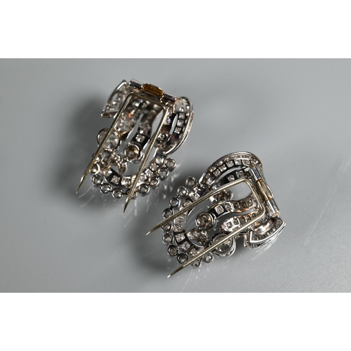 228 - A pair of Italian diamond fur clips, of opposing scroll form mounted overall with mixed cut diamonds... 