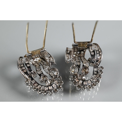 228 - A pair of Italian diamond fur clips, of opposing scroll form mounted overall with mixed cut diamonds... 