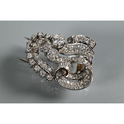 228 - A pair of Italian diamond fur clips, of opposing scroll form mounted overall with mixed cut diamonds... 