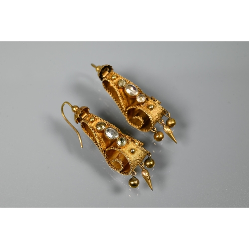 234 - A pair of Victorian textured yellow metal drop earrings of scroll form set with three foil backed st... 