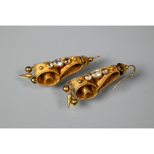 234 - A pair of Victorian textured yellow metal drop earrings of scroll form set with three foil backed st... 