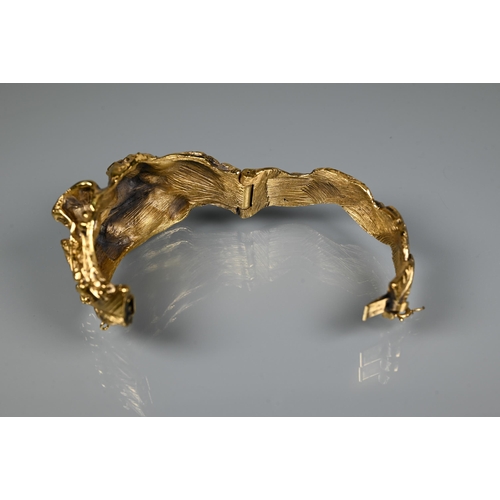 238 - Trifari - A gilt metal bangle of sculptural naturalistic form, half hinged with concealed clasp, 6 c... 