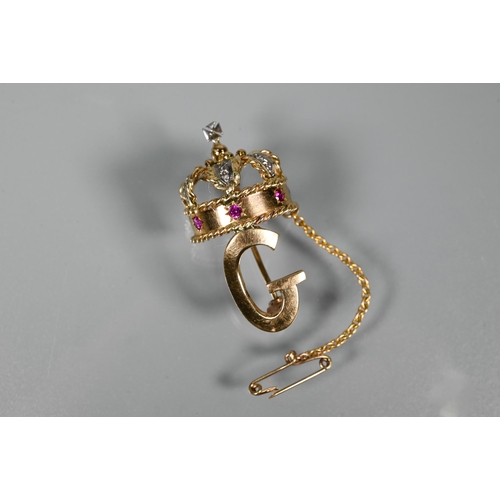 280 - A 1960s yellow metal brooch in form of a crown above the initial 'G', the crown set with rubies and ... 