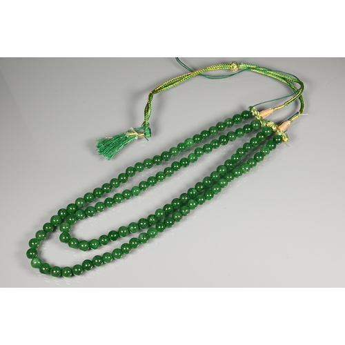 282 - A double row of uniform round emerald beads, on silk cord, 0.8 cm diam