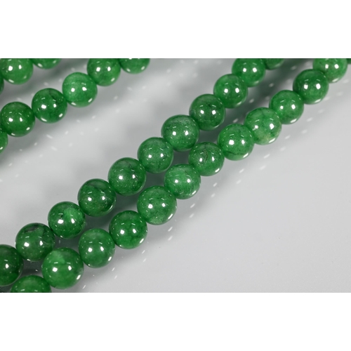 282 - A double row of uniform round emerald beads, on silk cord, 0.8 cm diam