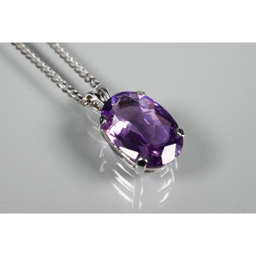 287 - An oval amethyst pendant in claw setting on flat linked white metal chain stamped 750, approx 5.9g (... 