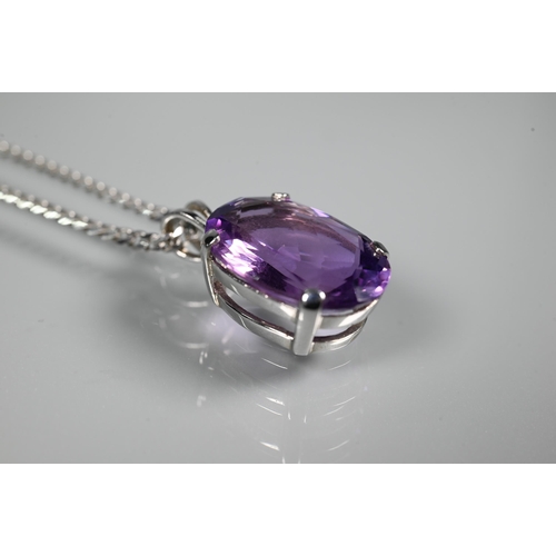 287 - An oval amethyst pendant in claw setting on flat linked white metal chain stamped 750, approx 5.9g (... 