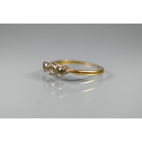 297 - An antique three stone diamond ring, the graduated diamonds in bezel settings, yellow gold set (mark... 