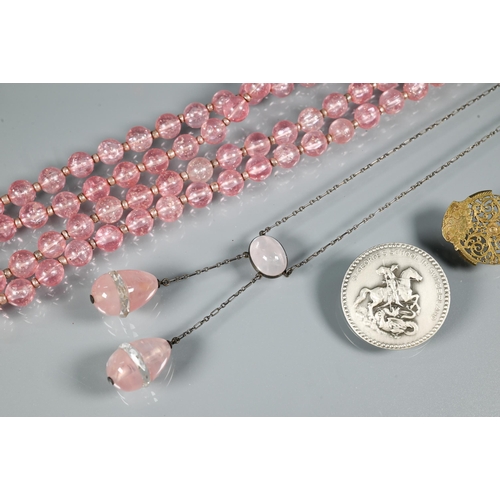 301 - An eary 20th century necklace formed of rose quartz ovoid drops from an oval centrepiece on white me... 