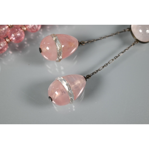 301 - An eary 20th century necklace formed of rose quartz ovoid drops from an oval centrepiece on white me... 