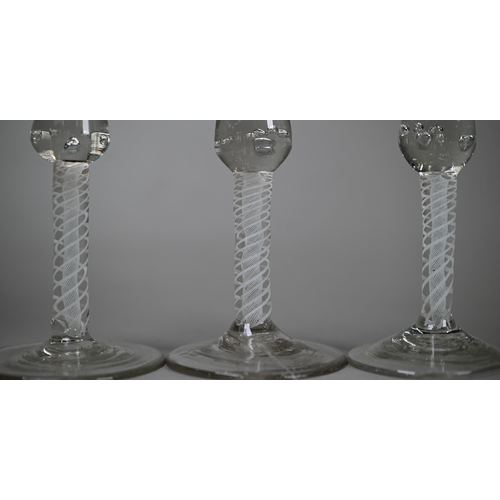 526 - Three 18th Century cordial glasses, the waisted bell bowls wheel-etched with fruiting vine decoratio... 