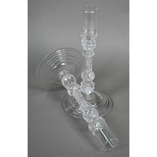 528 - A pair of antique glass candlesticks with plain cylindrical sockets on baluster stems with bubbles a... 