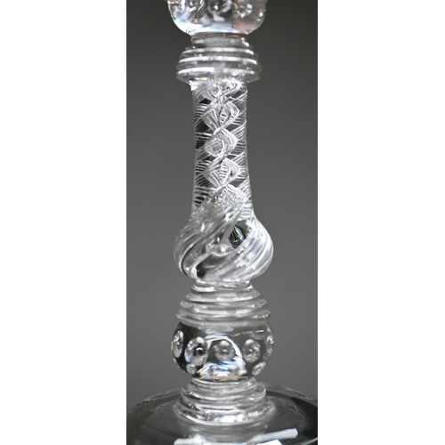 528 - A pair of antique glass candlesticks with plain cylindrical sockets on baluster stems with bubbles a... 